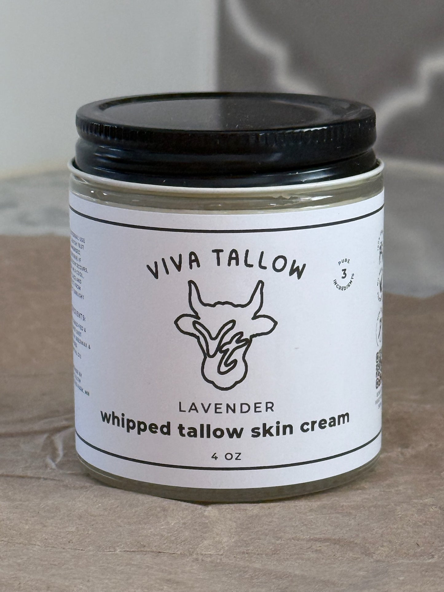 Jar of Viva Tallow lavender whipped tallow skin cream on a textured surface
